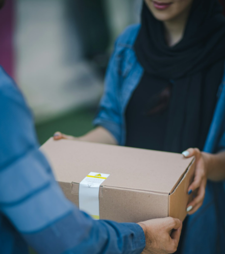 Person delivering a box to the front door